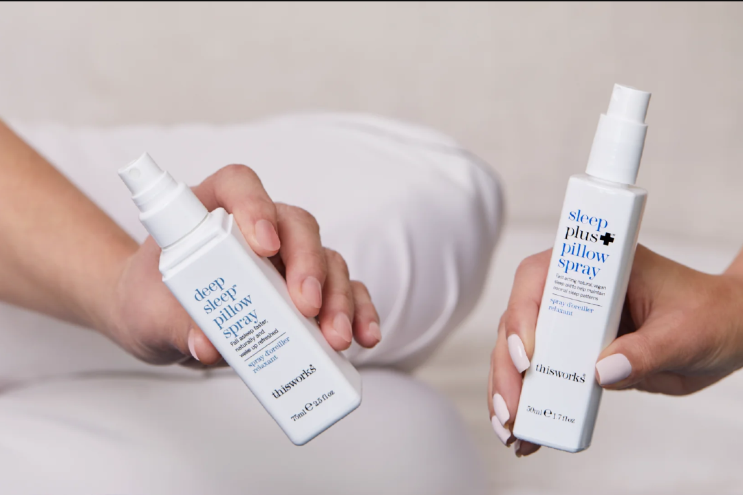 two hands holding This Works Deep Pillow Spray and Sleep Plus Pillow Spray