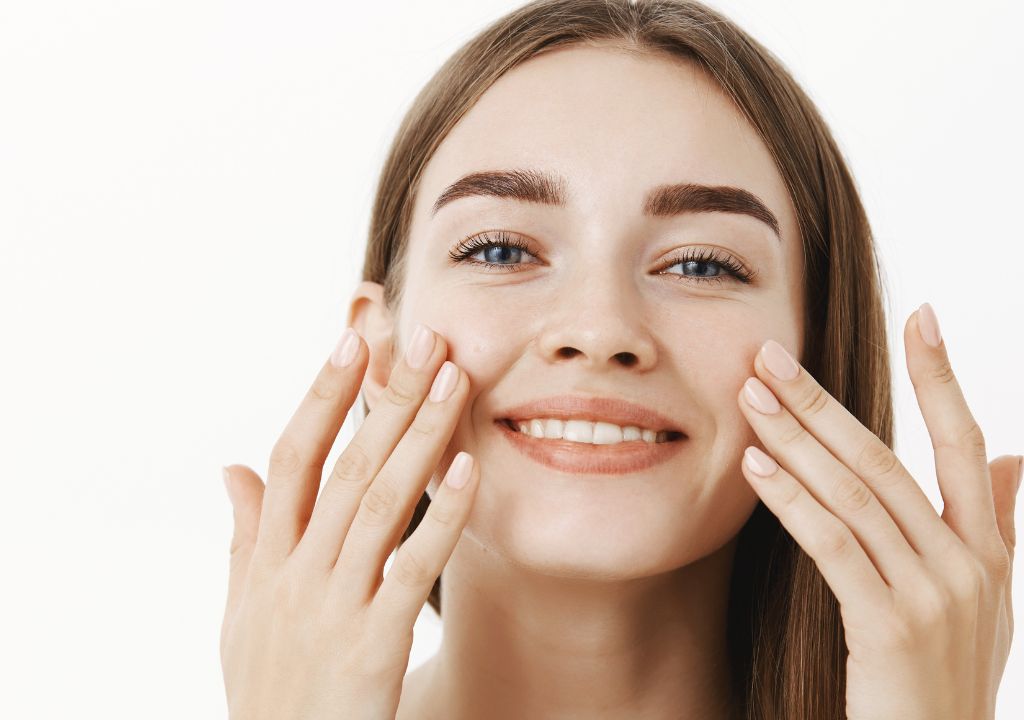 smiling lady massaging lotion into her face