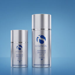 Two silver skincare bottles with a blue background