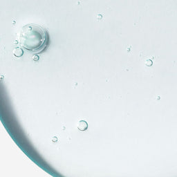 Close-up of clear liquid with bubbles on a light gray background