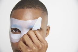 a closeup of a man taking the mask off his face