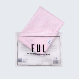 A folded light pink towel wrap with a subtle spiral pattern, partially pulled out of its clear plastic packaging. The packaging features a white label with black text reading 'FUL MICROFIBRE HAIR TOWEL WRAP'.