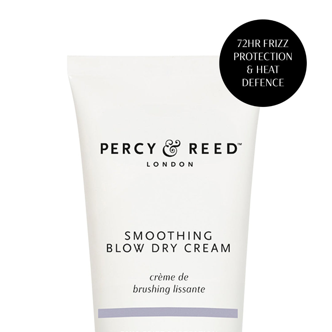A white squeeze tube of Percy & Reed London Smoothing Blow Dry Cream with black text, featuring a black circular badge on the top right that reads '72HR FRIZZ PROTECTION & HEAT DEFENCE'.