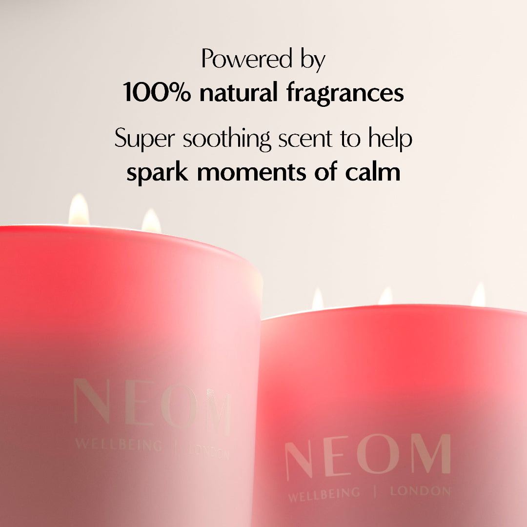 Two pink candles with NEOM branding on a light background, featuring text about natural fragrances.