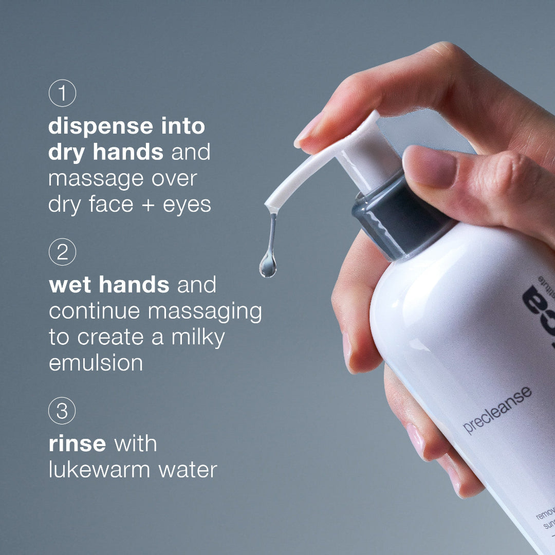 Hand holding a white bottle with text on a gray background