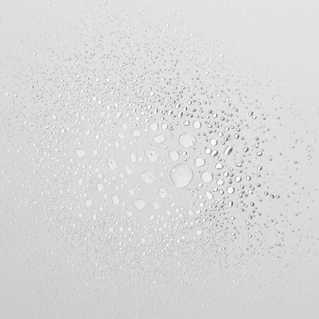 Water droplets on a glass surface with a light gray background