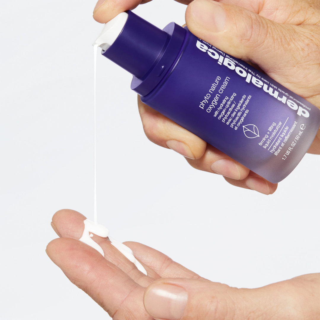 Hand holding a purple bottle of dermailogica skincare product with a clear background
