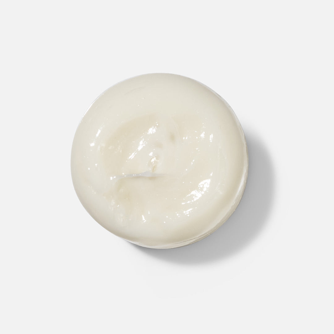 Round white candle on a light gray background