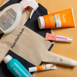 Various skincare products including bottles and tubes on a beige background with a tote bag.