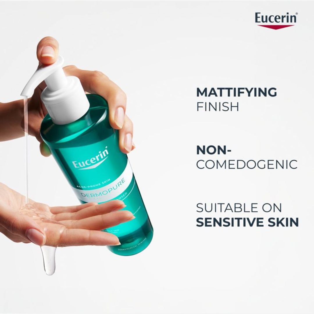 Eucerin Dermopure bottle being held with a person's hand, on a white background