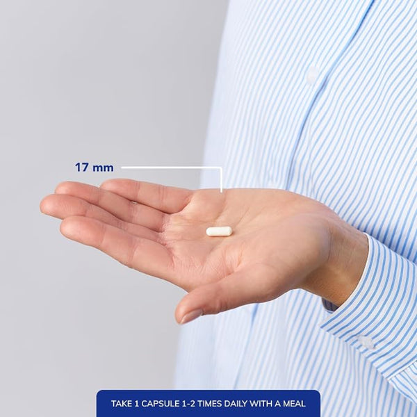 Hand holding a capsule with measurement label and text on a plain background