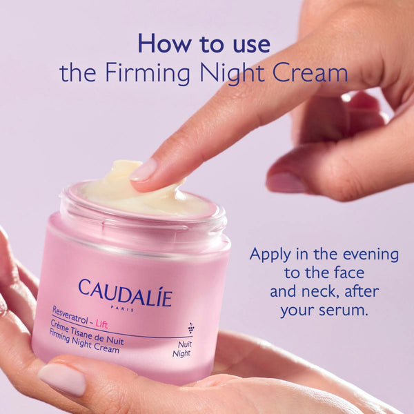 A hand applies cream from an open pink jar labeled CAUDALIE Reveratrol - Lift Crème Tisane de Nuit Priming Night Cream, with Portuguese instructional text on a soft lavender background.
