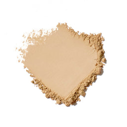 Heart-shaped pile of beige powder on a white background