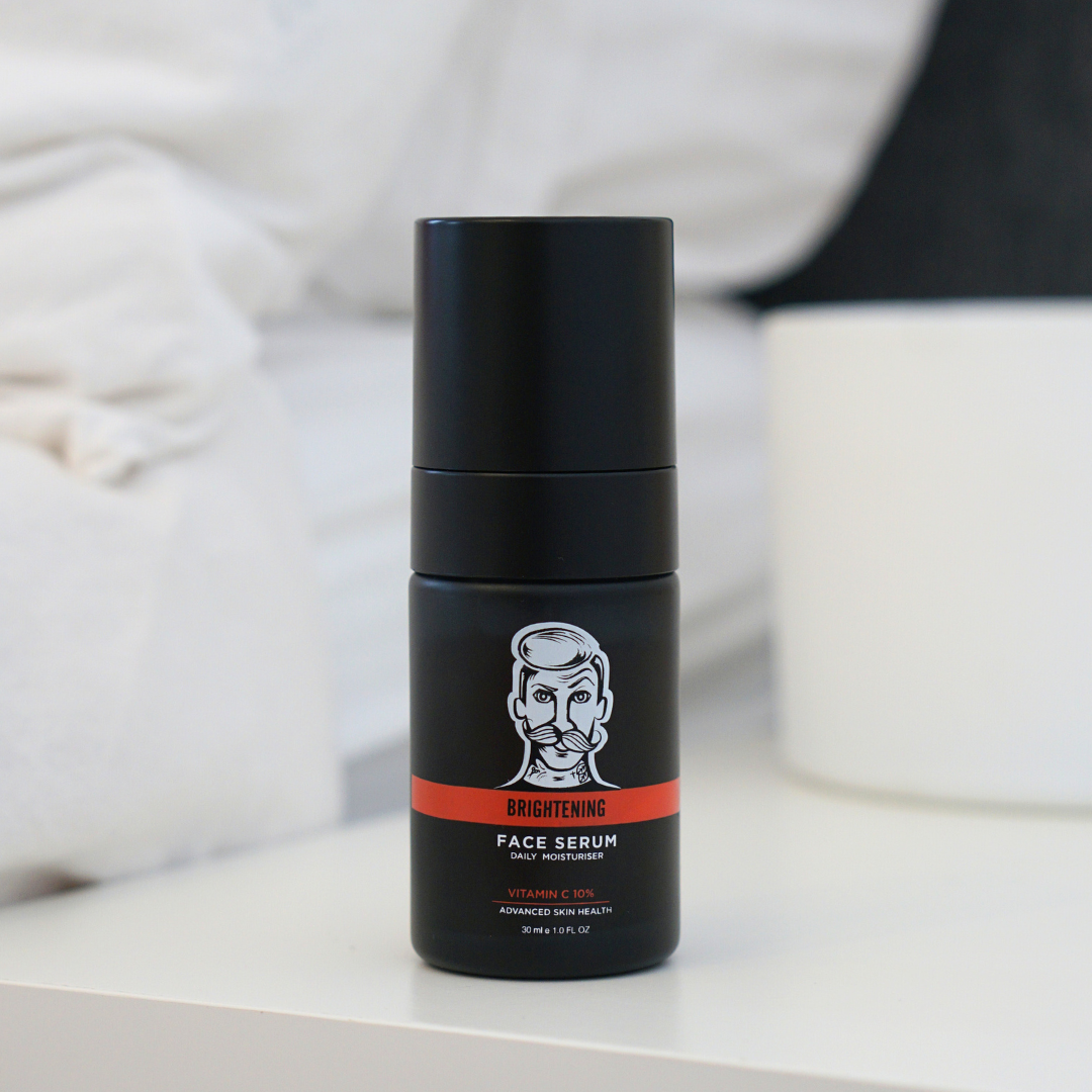 Black face serum bottle with a red label on a white surface