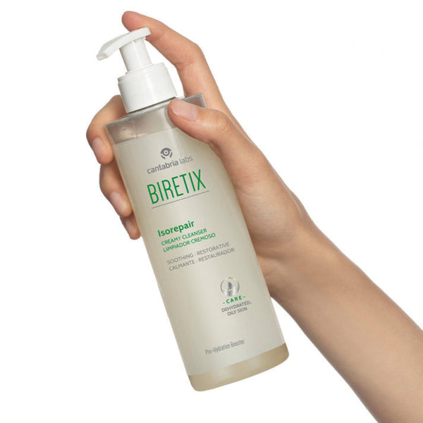Hand holding a Biretix bottle on a white background