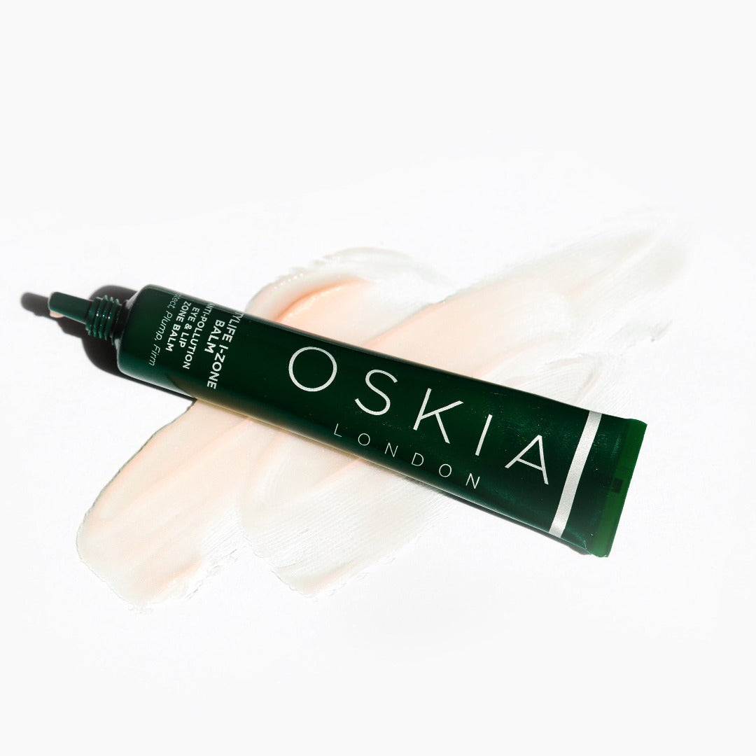 OSKIA CityLife I-Zone Lip & Eye Balm tube on top balm spread on a white surface