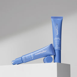 Two blue skincare products on a gray background