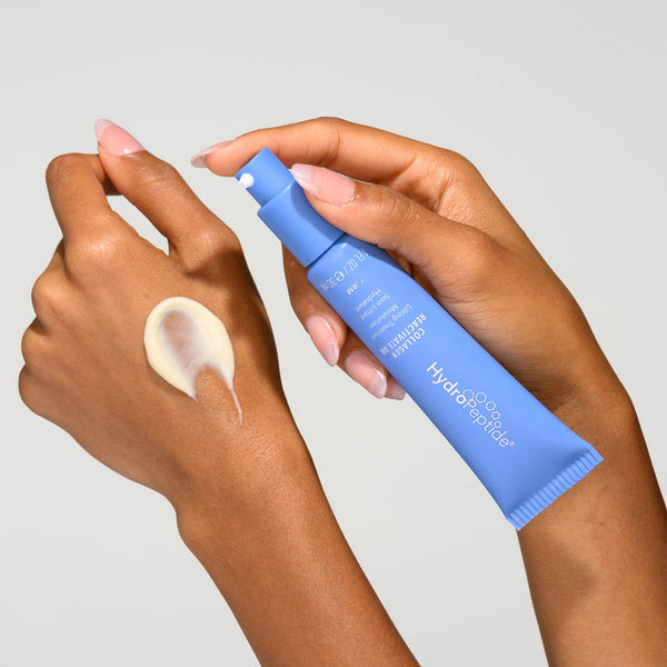 Hand holding a blue skincare product with a white background