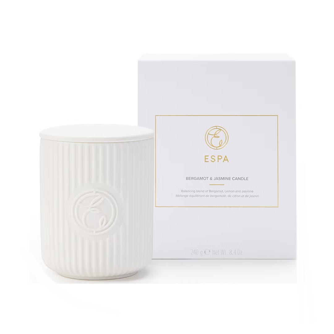 White candle with ribbed texture next to its packaging box on a white background