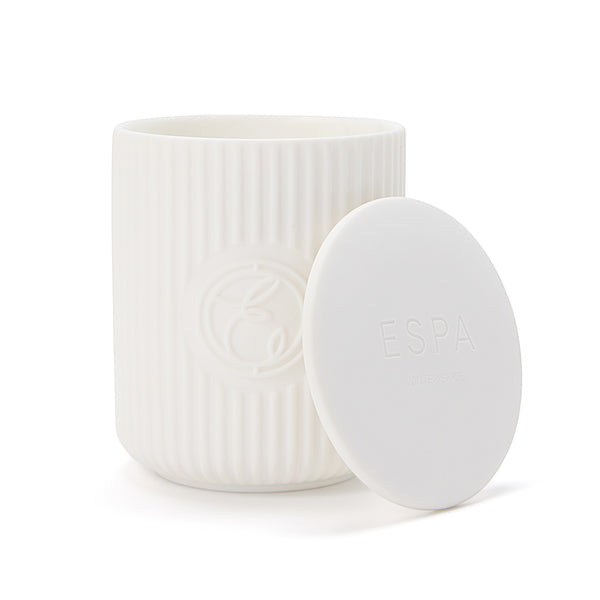 White candle with textured surface and lid on a white background