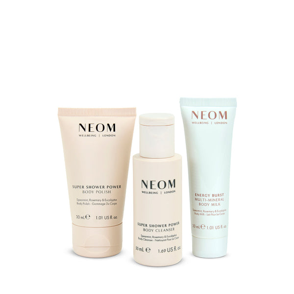NEOM skincare products including a body polish, cleanser, and milk on a white background