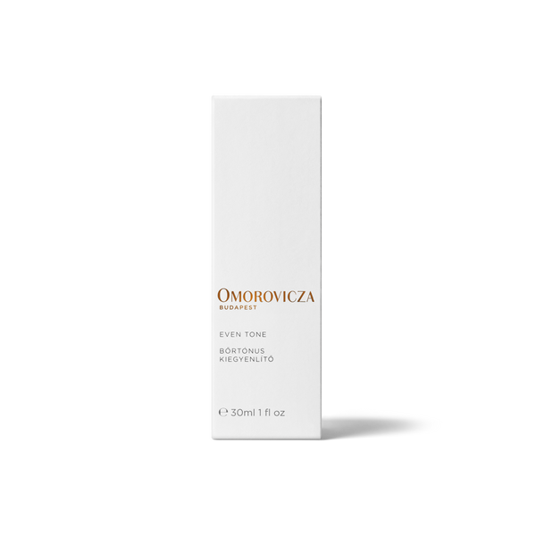 A tall, slim white rectangular box for Omorovicza Even Tone BB cream, featuring gold and gray text on a clean white background with a soft shadow.