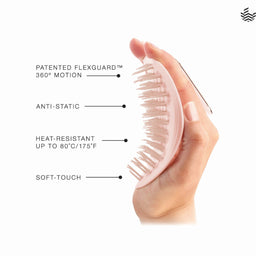 A hand holds a light pink oval hairbrush with soft bristles against a white background, with text callouts reading 'PATENTED FLEXGUARD 360° MOTION,' 'ANTI-STATIC,' 'HEAT-RESISTANT UP TO 80°C/175°F,' and 'SOFT-TOUCH.'.