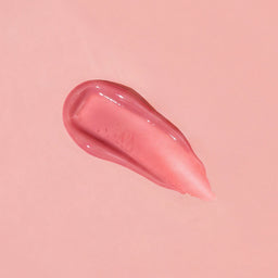 Pink lip balm smear on a pink background