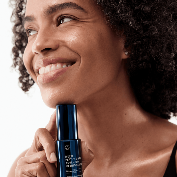 Woman holding a skincare product with a neutral background