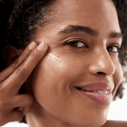 Woman applying cream to her face with a close-up view.