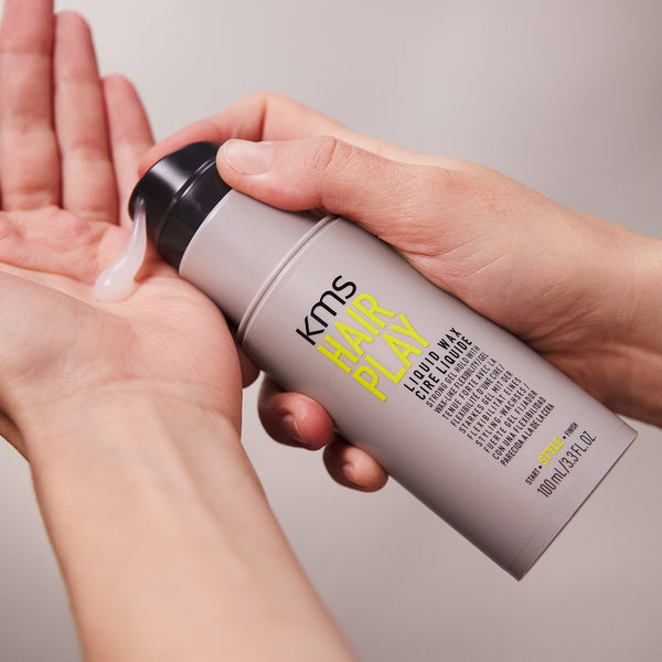 KMS Hair Play product being applied to a hand with a neutral background
