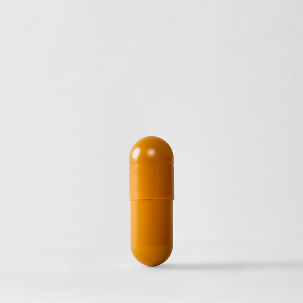 A single orange-yellow capsule pill standing upright on a light gray background.