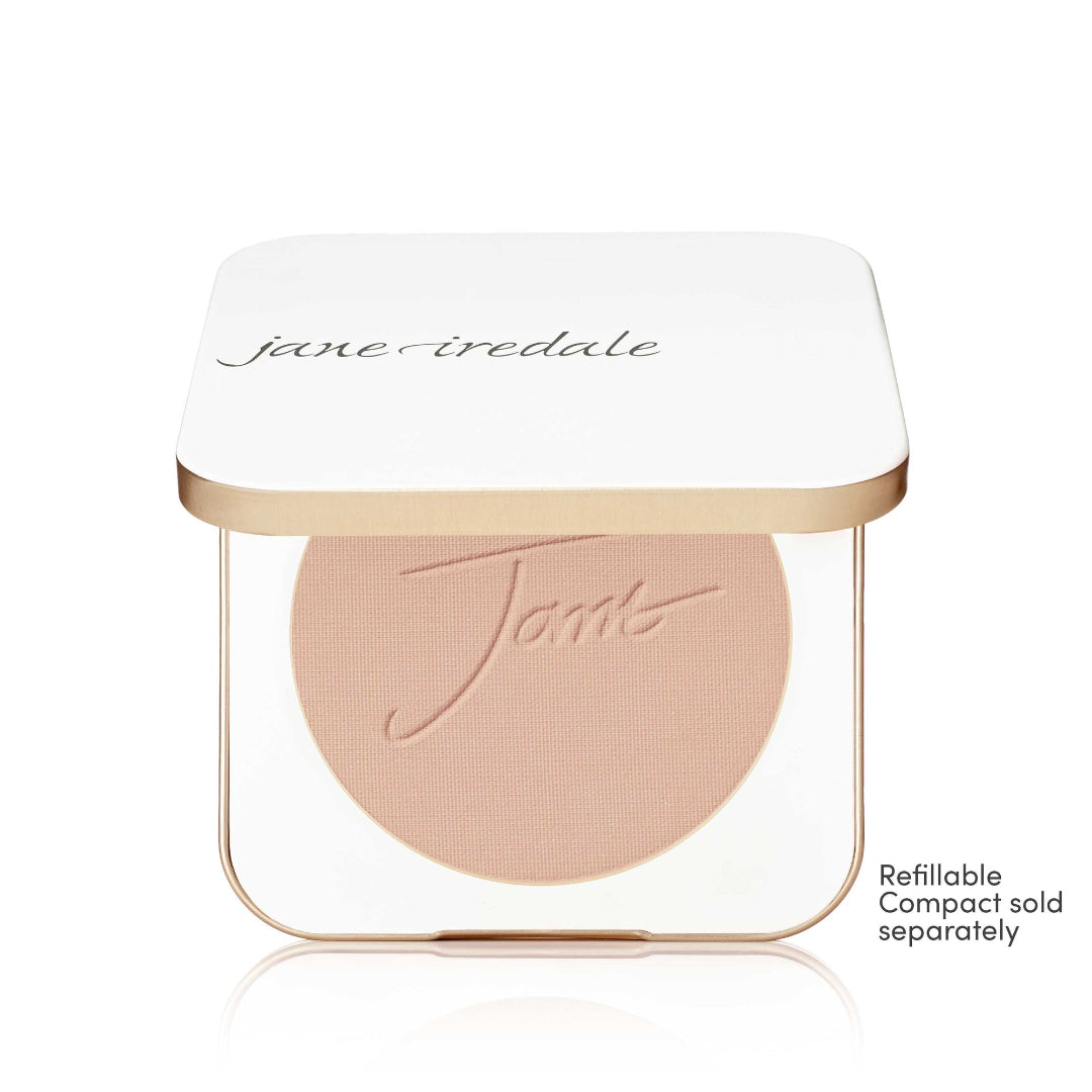 A Jane Iredale Tints refillable makeup compact shown open, revealing a circular pressed powder in a light peach-beige shade. The compact has a white lid with the brand name 'jane iredale' in black script and a gold metallic trim.