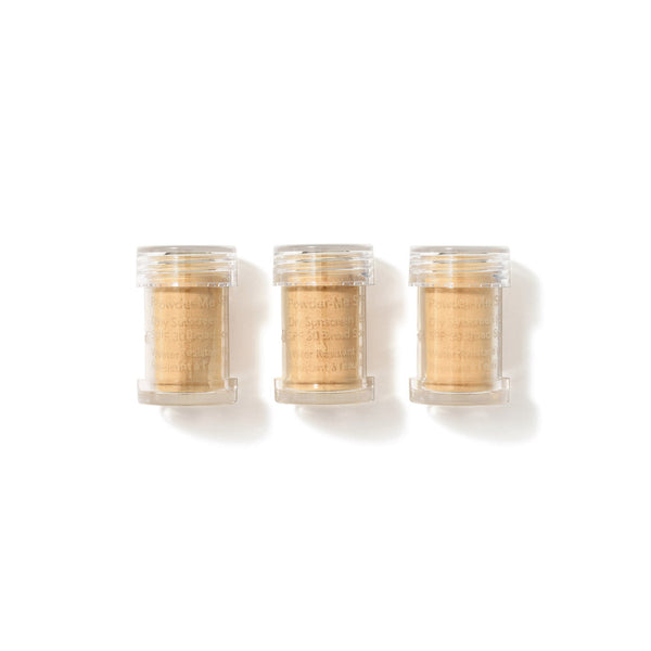 Three clear containers with gold contents on a white background