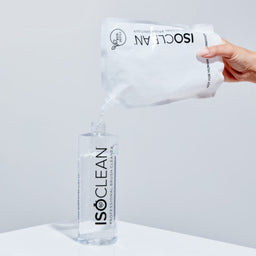 ISOCLEAN bottle and wipes on a white surface with a gray background