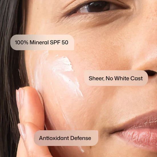 Close-up of a person's face with sunscreen applied, highlighting SPF 50, no white cast, and antioxidant defense features.