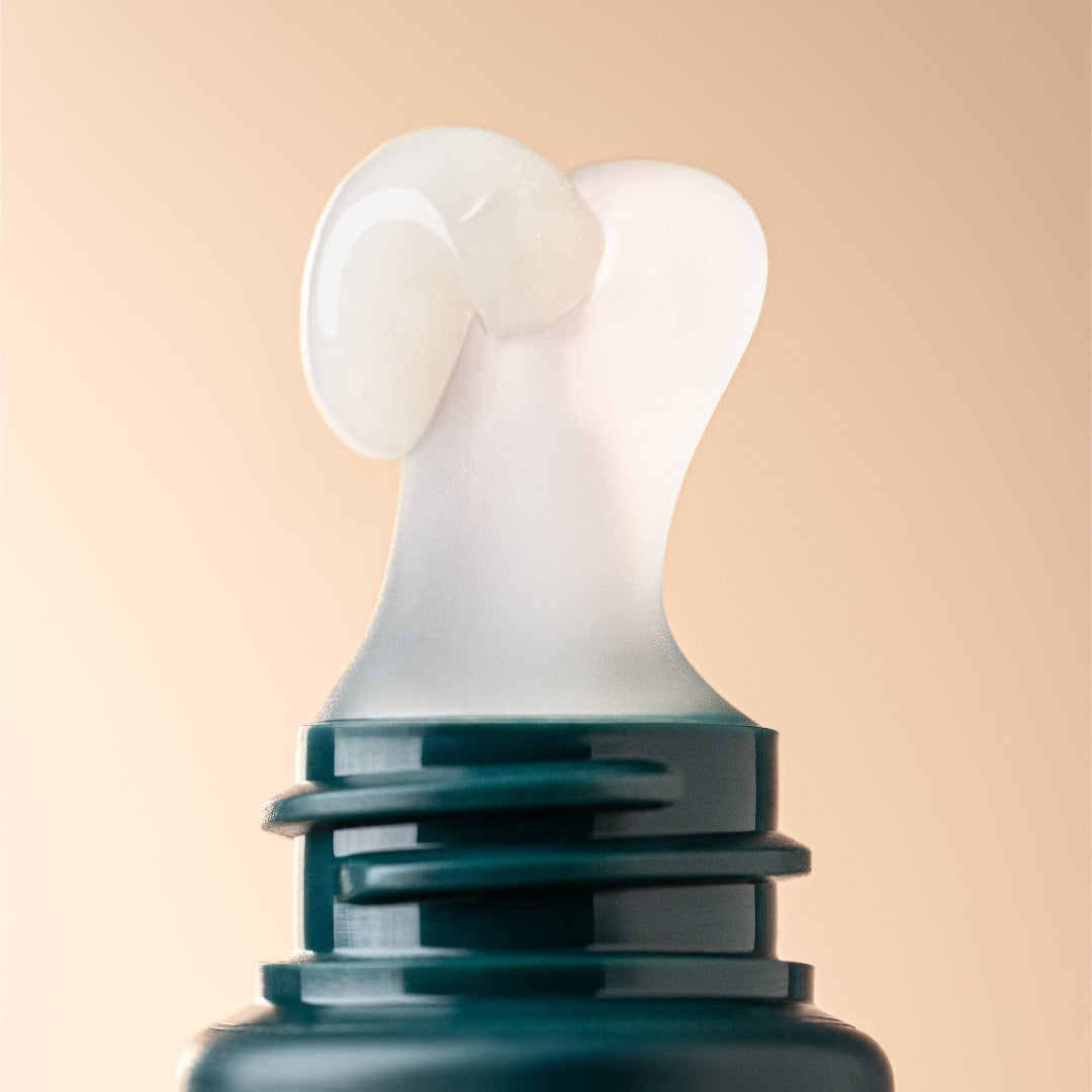 Close-up of a teal bottle with a white cap on a beige background
