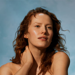 Woman with sun-kissed skin against a blue sky