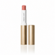 A tube of lipstick with its cap removed, standing upright on a white reflective surface. The lipstick bullet is a muted peach-pink, the inner tube is white with black script text reading 'jane teddie', and the outer casing is metallic gold.