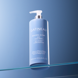 A bottle of Gatineau Paris Renewal Ultime AHA Body Wash, 400ml, standing on a reflective glass surface against a blue gradient background.