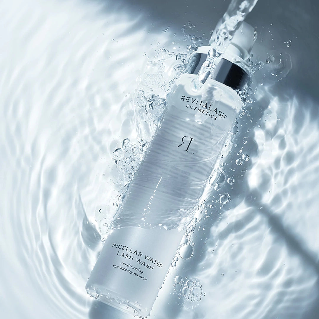 Revitalash Micellar Water Lash Wash bottle with water droplets and ripples in the background