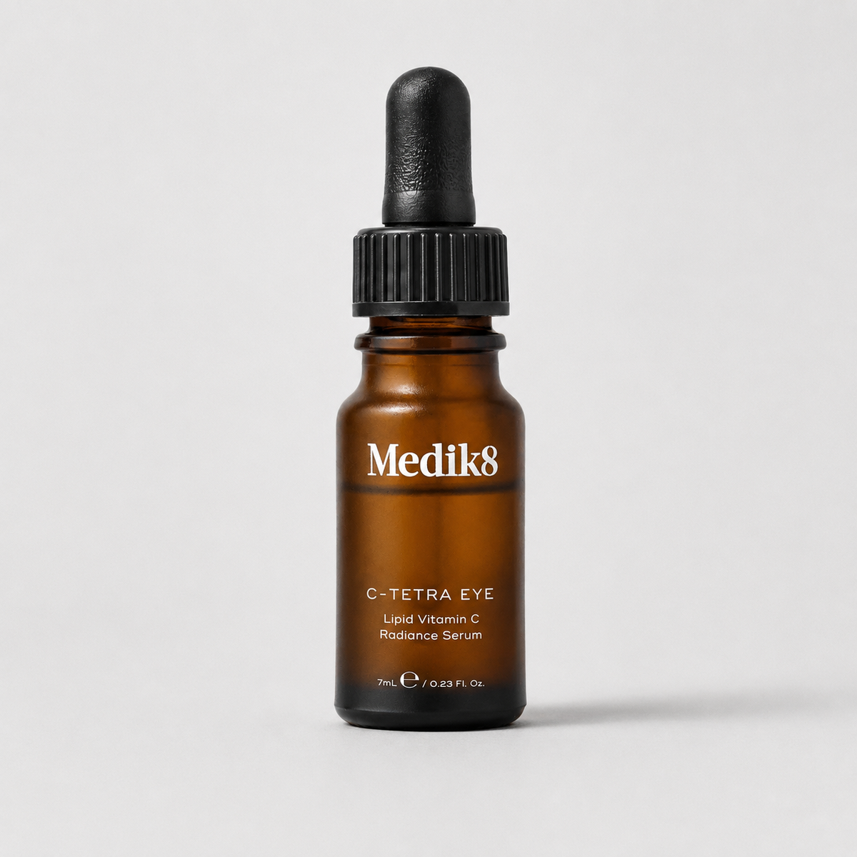 Medik8 C-Tetra Eye Liquid Vitamin C Radiance Serum in an amber glass dropper bottle with a black cap, centered on a light gray background.