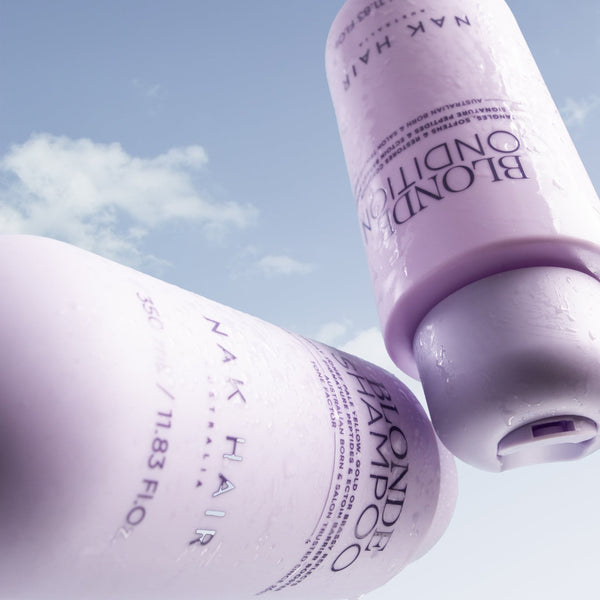 Two bottles of Nak Hair Shampoo and Conditioner against a blue sky background