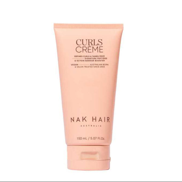 A tube of NAK HAIR Curls Creme hair product in a soft peach-pink color, centered on a plain white background.