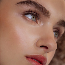 Close-up of a woman's face with a focus on her eye and nose.