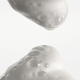 Close-up of a textured white object with bubble-like patterns on a light gray background