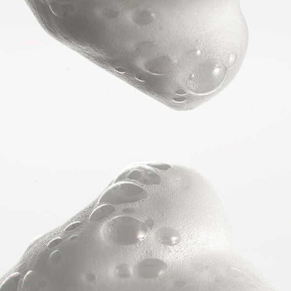 Close-up of a textured white object with bubble-like patterns on a light gray background