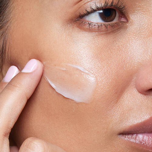 a woman applying SkinCeuticals Metacell Renewal B3 to her cheek