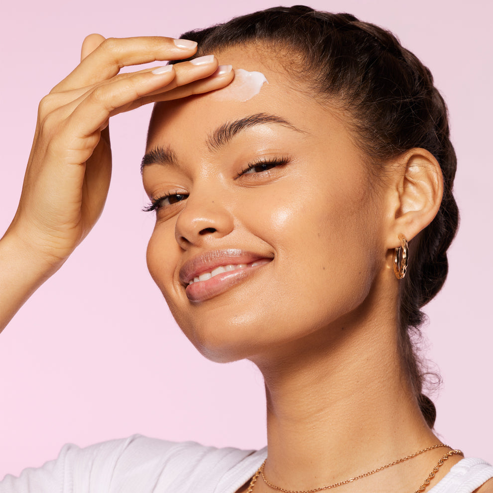 a model applying the scrub to her face