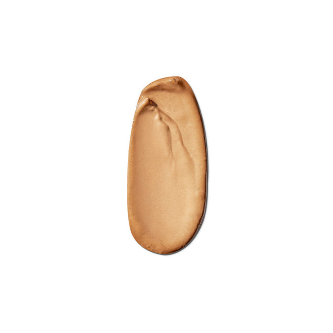 A smooth, swirled smear of light tan liquid foundation or cream makeup on a solid white background.